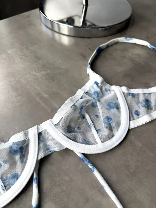 Комплект складається з бюстгальтера на тонких бретелях та трусиків стрінгів середньої посадки.